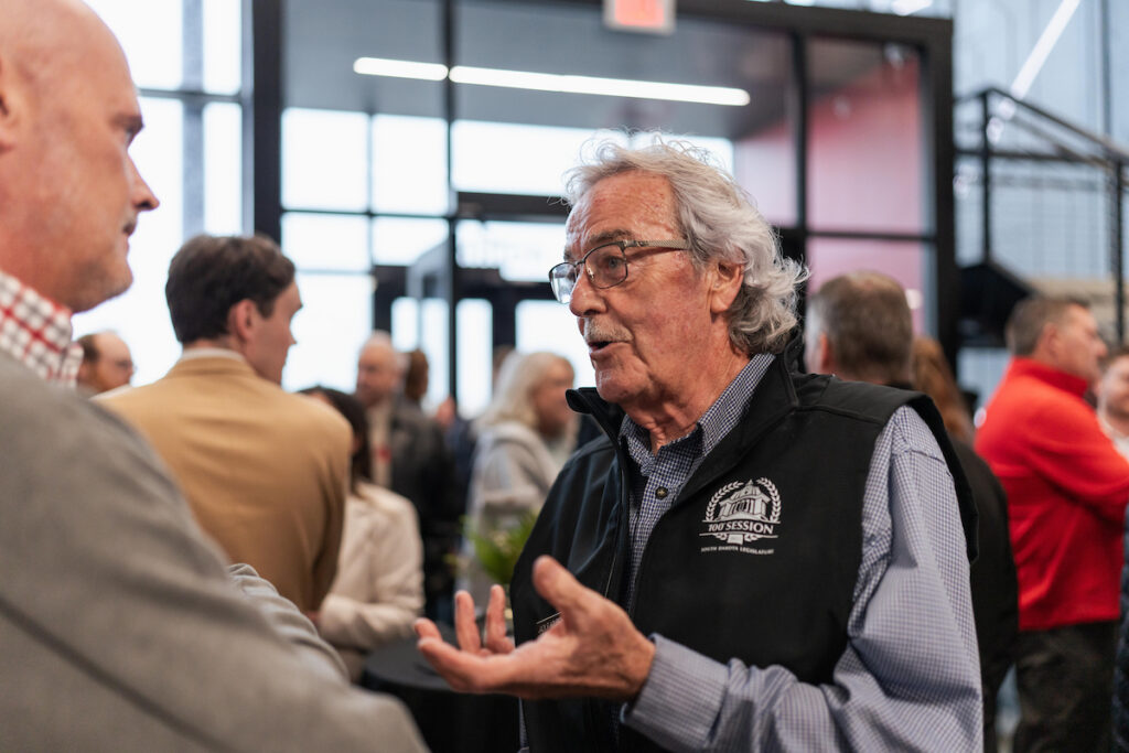 Attendees network inside the modern lobby of the USD Discovery District during the grand opening event.
