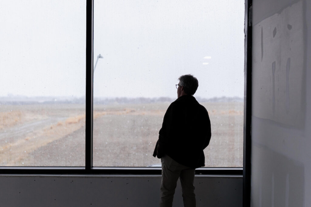 A man looks out over the snowy landscape from inside the newly opened USD Discovery District building.
