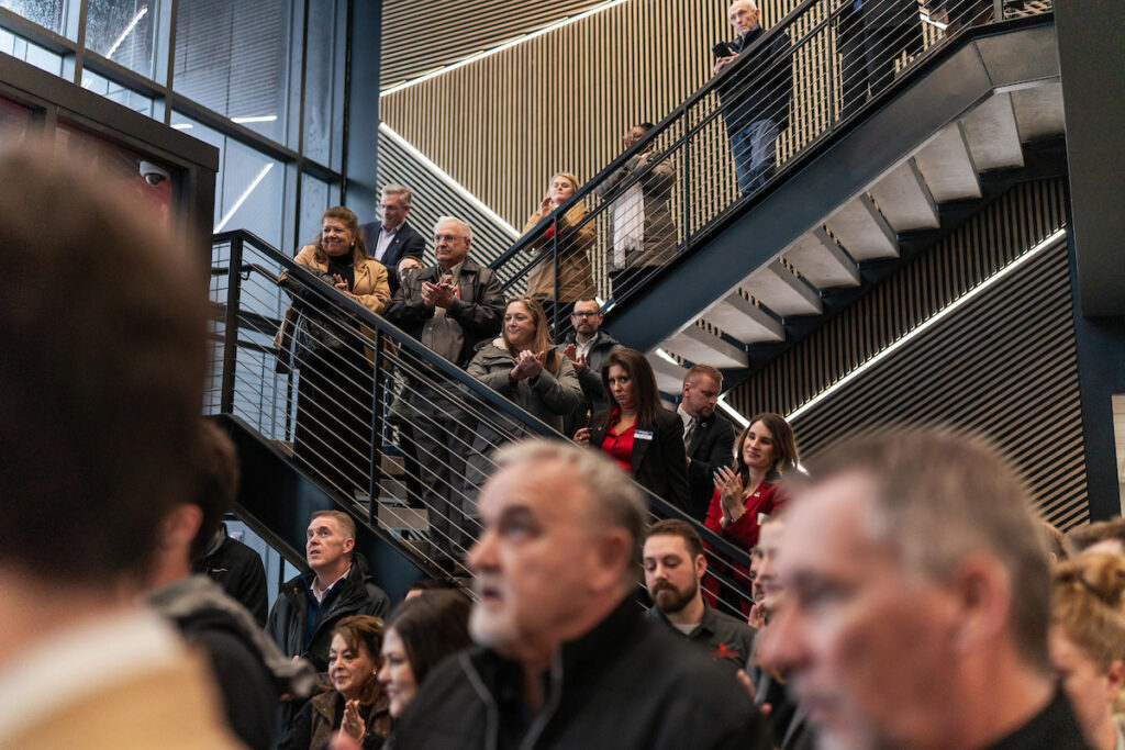 Guests and partners stand along the staircase inside USD Discovery District Building 1 during the grand opening celebration.