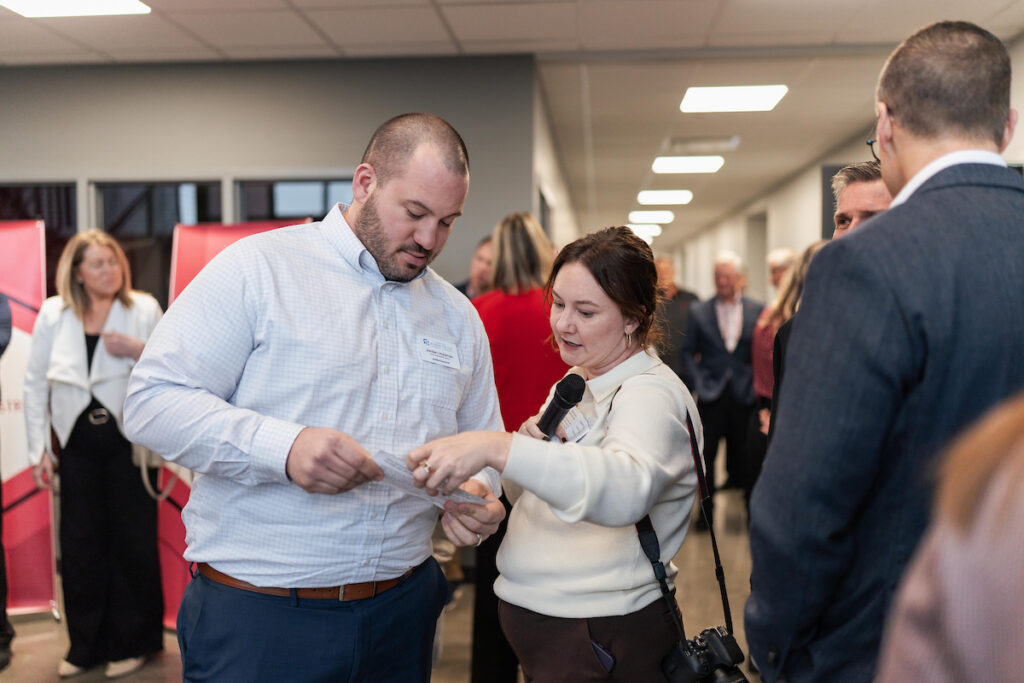 Guests converse and review materials in a hallway during the USD Discovery District Grand Opening event.
